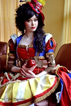 a woman dressed as snow white sitting on a chair with an apple in her hand