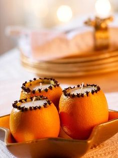 three oranges with candles in them sitting on a table