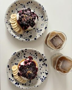 two white plates topped with desserts and banana slices next to glasses of ice cream