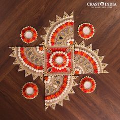 an intricately decorated diya with candles on a wooden floor in the shape of a flower