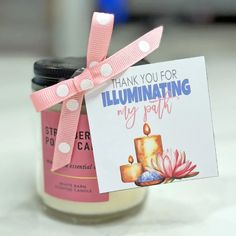 a pink candle with a card attached to it