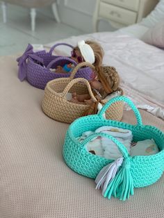 three crocheted purses sitting on top of a bed