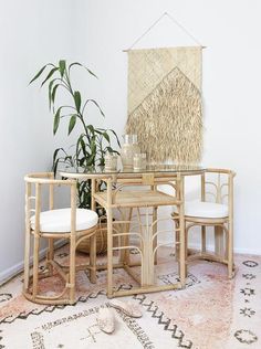 a table and chairs in a room with a rug on the floor next to it