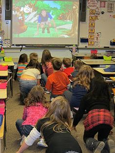 a group of children sitting in front of a classroom