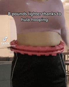 a woman is wearing a pink shirt and black pants with her stomach exposed in the shape of a belt