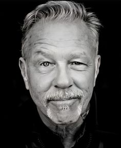 a black and white photo of an older man with a goatee on his head