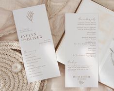 two wedding programs are laying next to each other on a table with a wicker basket