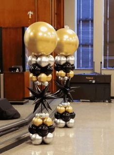 some black and gold balloons are on the floor