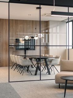 a glass walled meeting room with chairs and tables