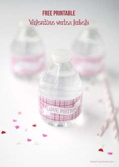 three plastic water bottles sitting on top of a table with confetti around them