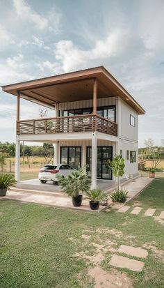 a house with a car parked in front of it on top of a grass covered field