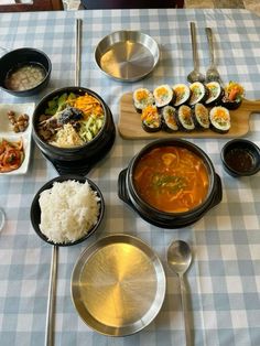 a table topped with lots of different types of food on top of a blue and white checkered table cloth