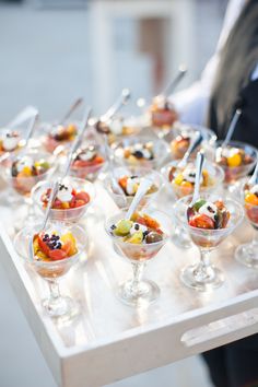 many small cups filled with different types of food