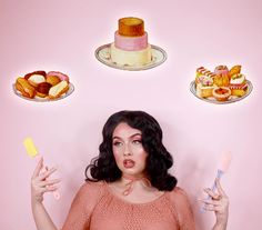 a woman holding two toothbrushes in front of her face with pastries above her head