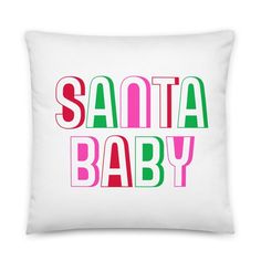 a white pillow with the words santa baby in pink, green and red on it