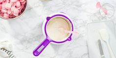 a cup filled with marshmallows on top of a counter next to other items