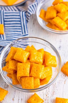 two bowls filled with cubed tofu sitting on top of a white wooden table