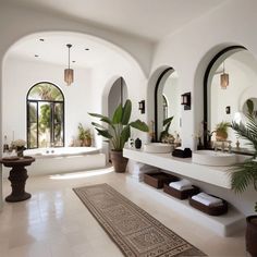 a large bathroom with two sinks and mirrors on the wall, along with potted plants