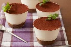 three desserts are sitting on a purple and white checkered cloth