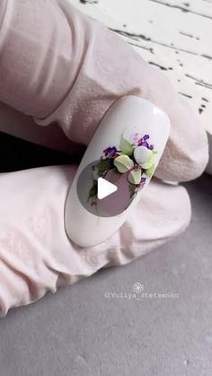 a person wearing white gloves with flowers painted on their nails and the thumbnails