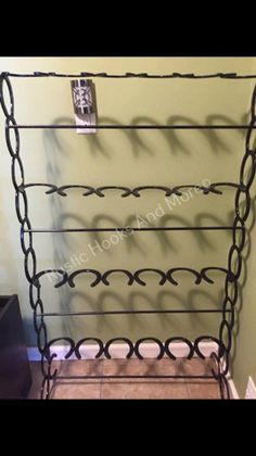 a metal rack with several chains hanging from it's sides and two pictures on the wall