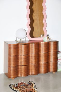 a dresser with a mirror and rug on the floor