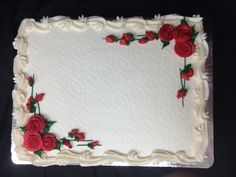 a sheet cake with white frosting and red roses on it