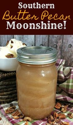 a mason jar filled with butter pecans sitting on top of a plaid table cloth