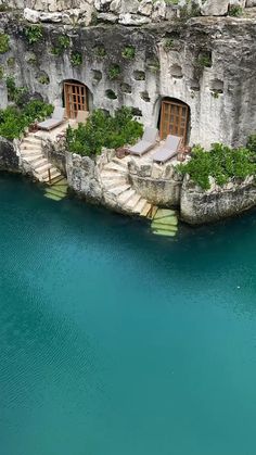 an aerial view of the water and stairs leading up to two rooms with plants growing out of them