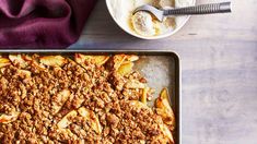 an apple crumbled dessert on a pan next to a bowl of ice cream