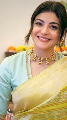 a woman wearing a yellow sari and smiling at the camera