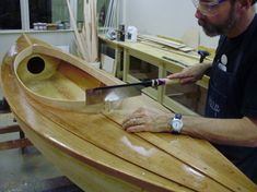 a man is working on a wooden boat