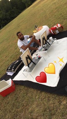 a man sitting at a picnic table with hearts on it