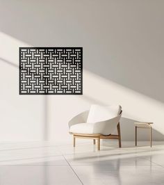 a white chair sitting in front of a black and white art piece on the wall