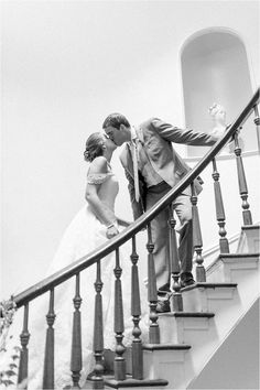 a bride and groom are kissing on the stairs