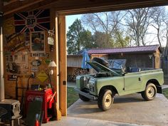 an old green truck parked in a garage