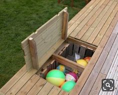 an outdoor play area made out of pallets and wooden boards with balls in it