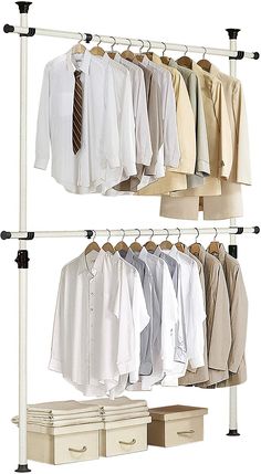 an image of clothes hanging on rails in the closet with two drawers and three shirts