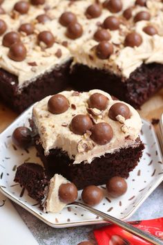 two pieces of chocolate cake with white frosting and chocolate candies