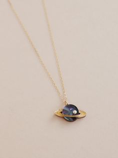 Did you know...sometimes it rains diamonds on Saturn! Our miniature version of this magical planet comes in marbled midnight acrylic, embellished with a high quality glass pearl & crystal. Purchase with a one of our chains or add the pendant onto one you already have. Photographed on a 45cm 14k gold-filled flat cab Space-themed Pendant Jewelry For Gift, Space-themed Pendant Jewelry Gift, Handmade Cosmic Style Jewelry For Gifts, Cosmic Style Handmade Jewelry As A Gift, Handmade Cosmic Jewelry For Gifts, Celestial Pearl Pendant Jewelry As Gift, Celestial Round Jewelry For Parties, Space-themed Gold Jewelry Gift, Orb-shaped Metal Jewelry As Gift