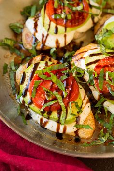 chicken with tomatoes, avocado and sauce on a silver platter ready to be eaten