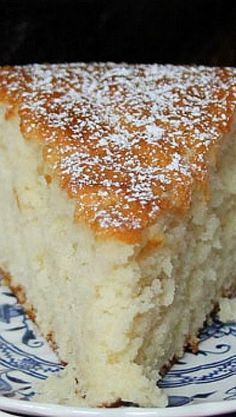 a piece of cake sitting on top of a blue and white plate covered in powdered sugar