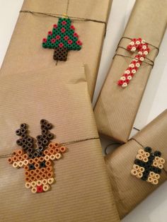 three pieces of fabric with bead designs on them, one has a christmas tree and the other is a reindeer