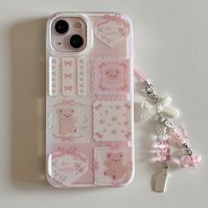 an iphone case with pink stickers on it next to a keychain