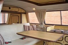 the inside of a camper with wooden tables and couches