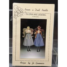 there are two dolls that are standing in front of a card with the words never a dull needle