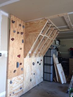 an unfinished room with wooden walls and climbing wall