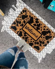 someone is standing in front of a welcome mat with leopard print and the words welcome home on it