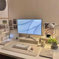 a computer monitor sitting on top of a desk next to a keyboard and mouse pad