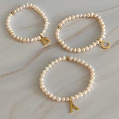 Adorn your wrist with a stylish Freshwater Pearl Initial Charm Bracelet. Featuring freshwater pearls and a clean font initial charm, this bracelet provides both timeless elegance and personalization. It makes the perfect gift for yourself or your loved ones and is suitable for everyday wear or special occasions. Stack it with other bracelets for a stunning layered look. Dimensions: approximately 6.5" before stretch Genuine freshwater pearls 18k gold plated stainless steel initial charm with wate Bracelets With Initials, Clean Font, Letter Bracelets, Initial Charm Bracelet, Visor Hairstyles, Perfume And Cologne, Hair Setting, Pearl Collection, Moissanite Jewelry